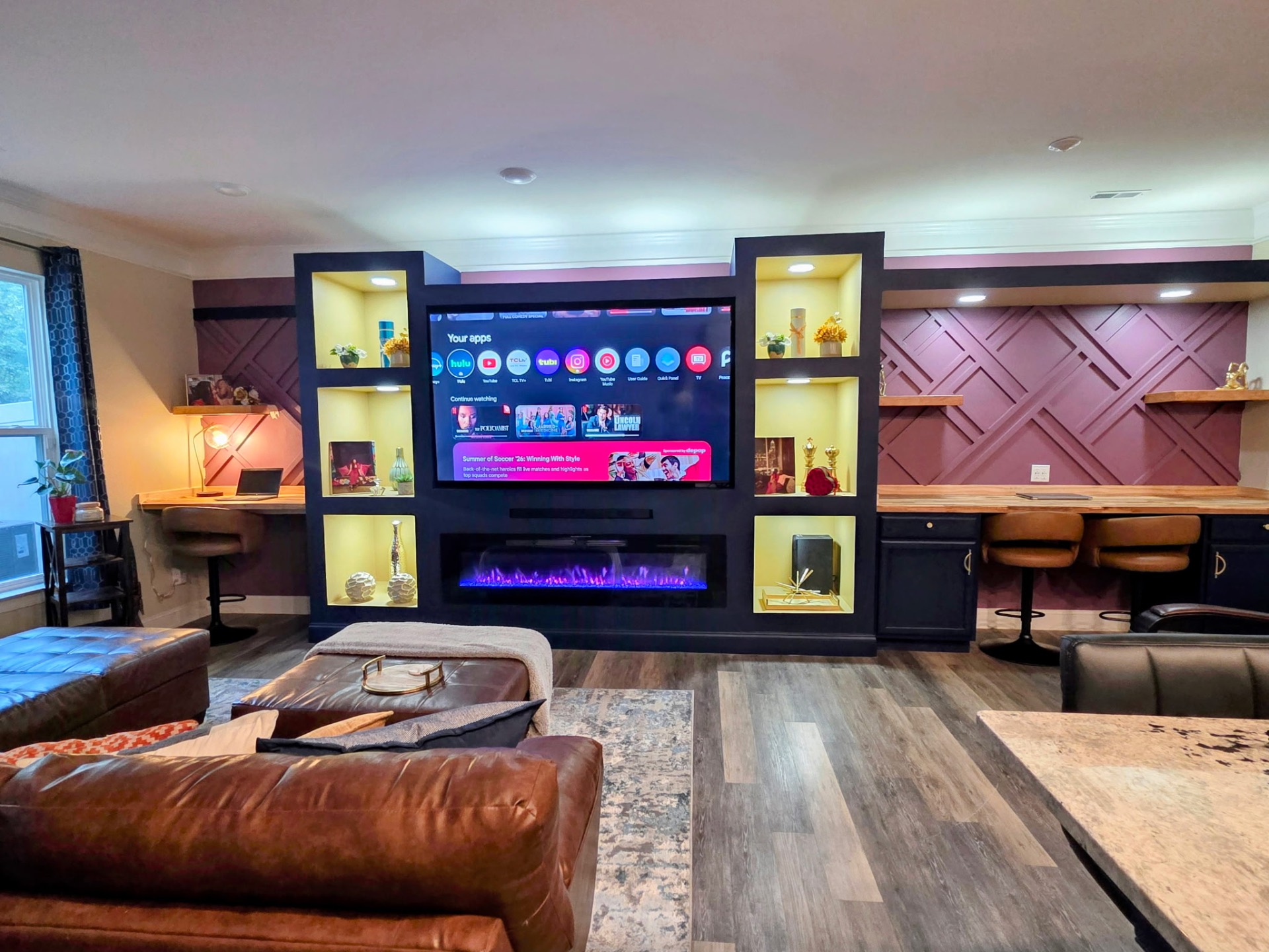 Custom black entertainment wall with linear fireplace, backlit display niches, and paneled accent wall by Imperial Design & Build