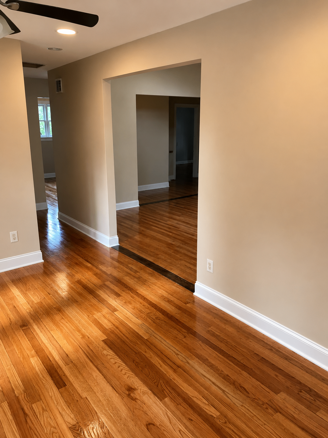 Open living area with newly refinished hardwood floors and fresh trim