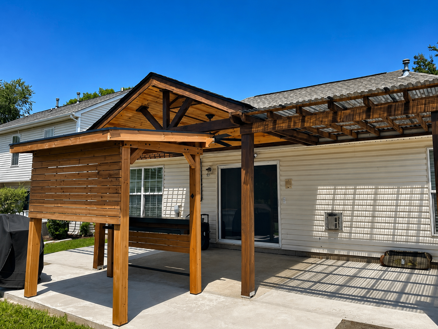 Exterior view of custom covered patio with gable roof and attached pergola
