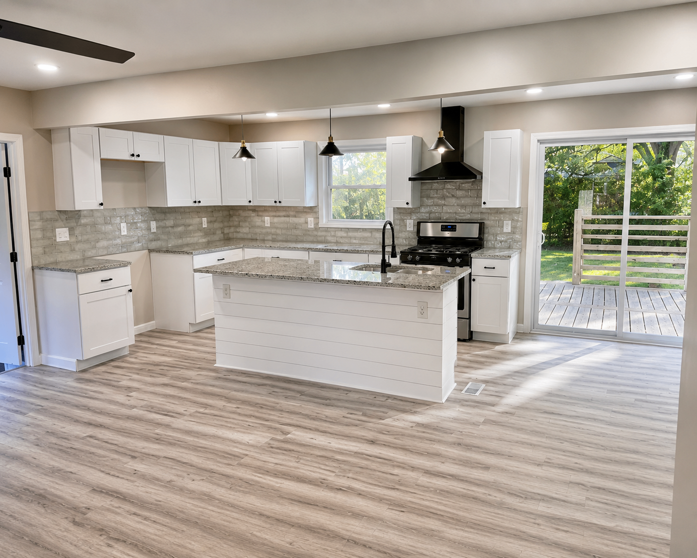 Open-concept kitchen with white shaker cabinetry, granite counters, and shiplap island