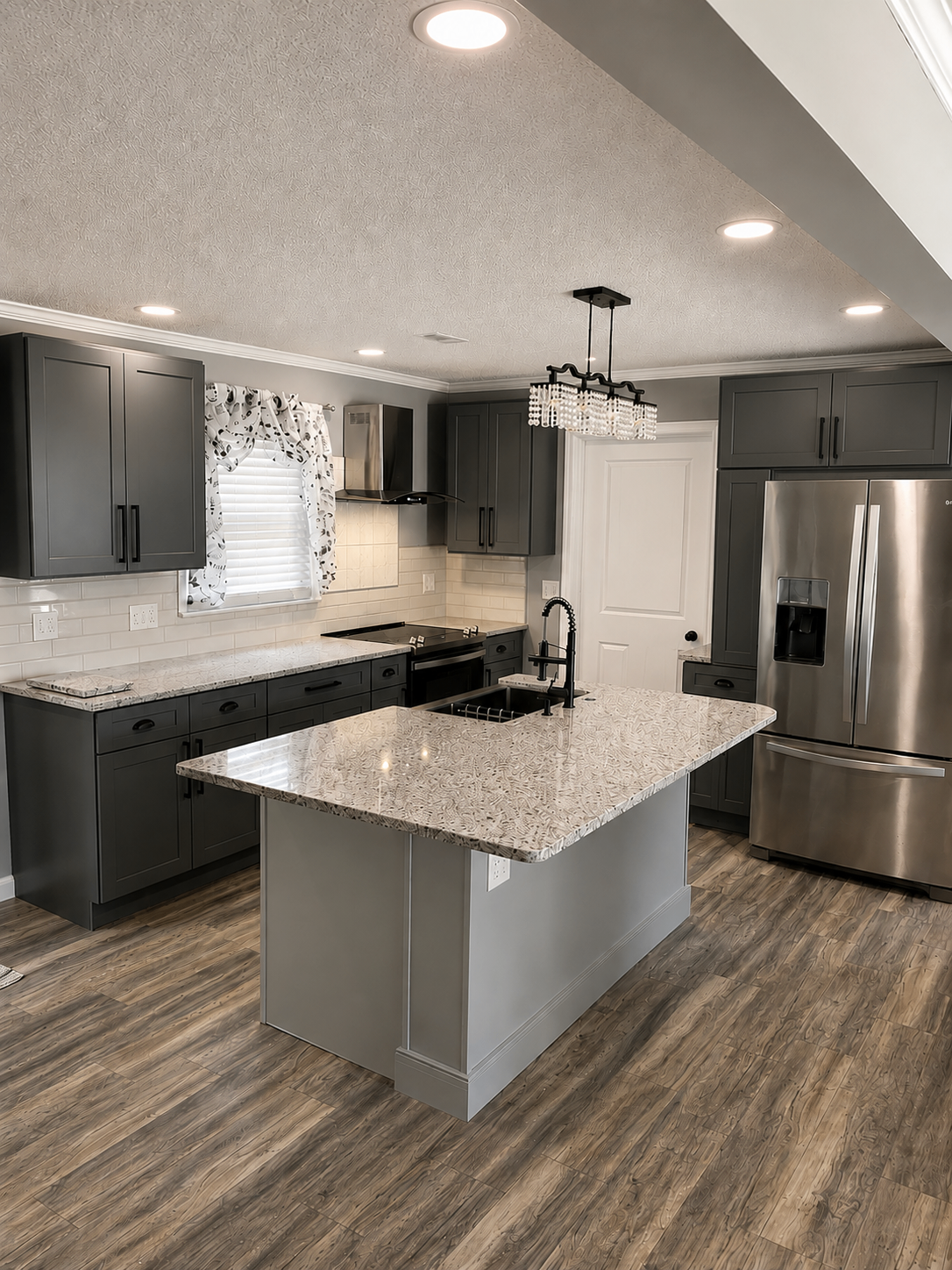 Modern kitchen renovation with charcoal cabinetry, granite island, and stainless appliances
