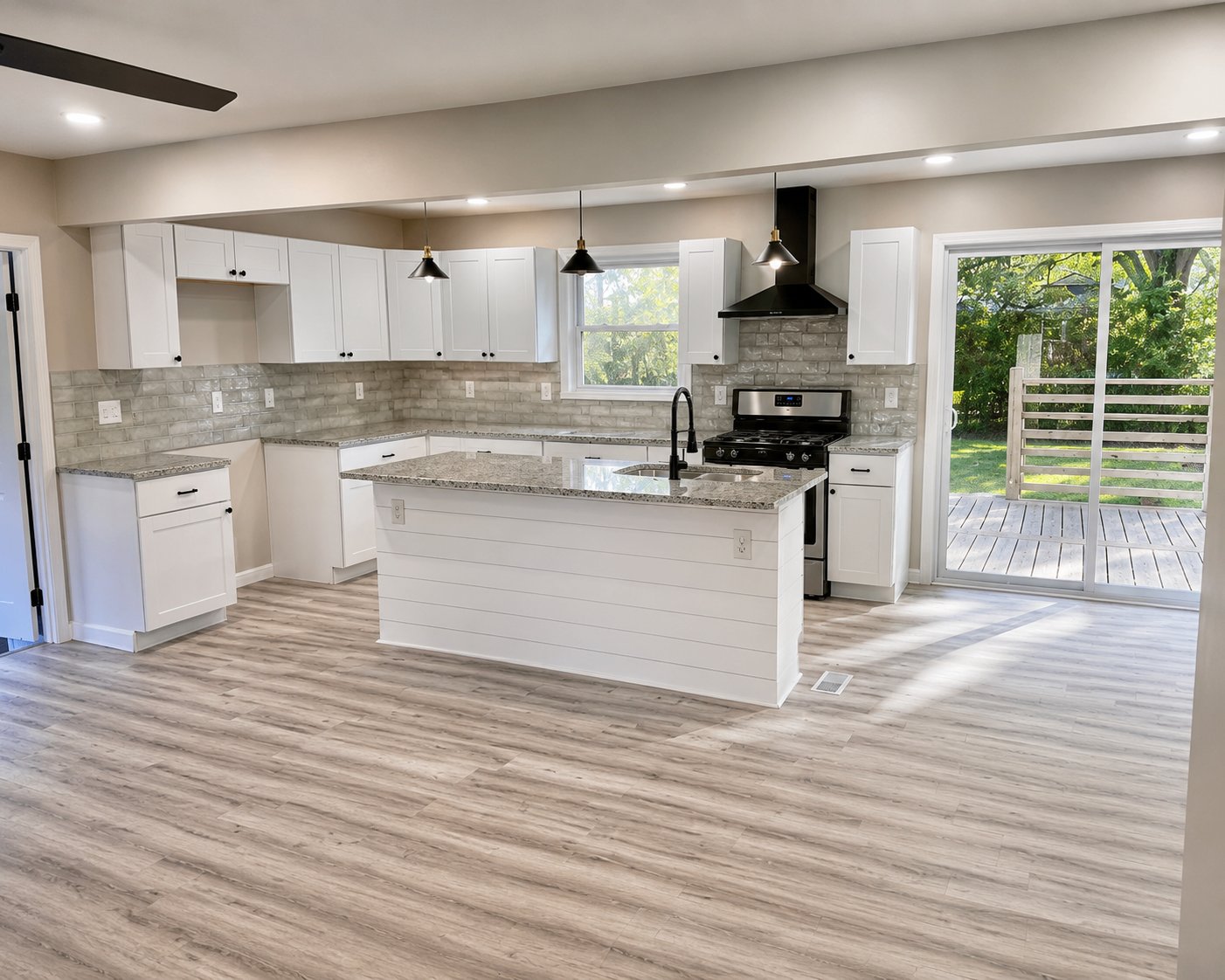 Open-concept kitchen with white shaker cabinetry, granite counters, and shiplap island
