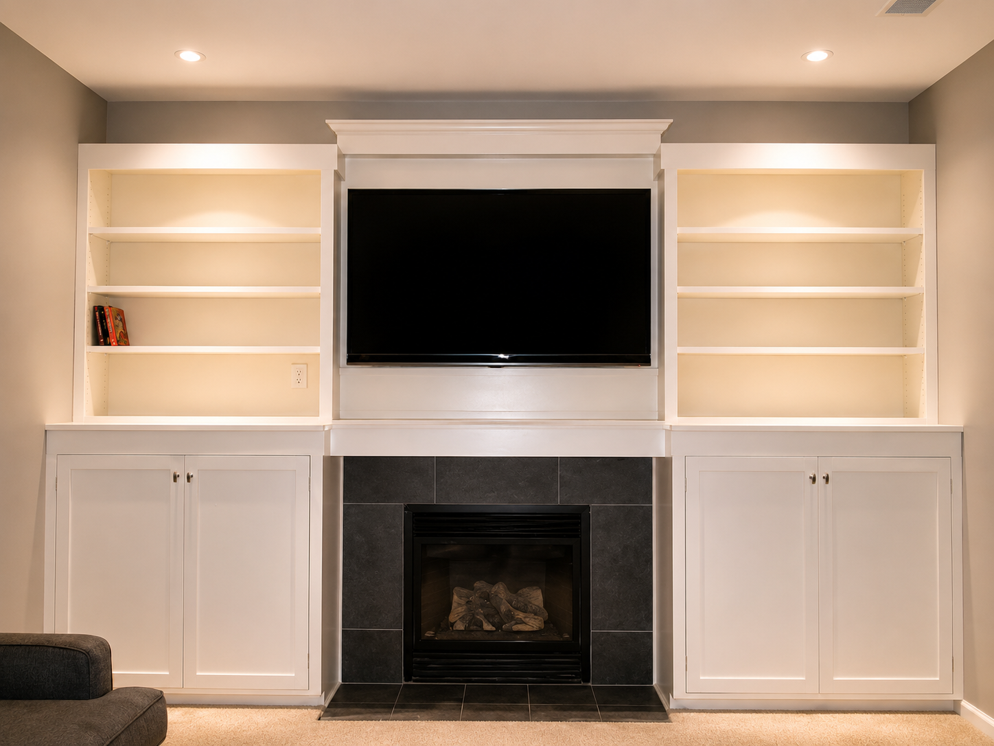 Custom white built-in media wall with fireplace surround, flanking bookshelves, and shaker cabinetry