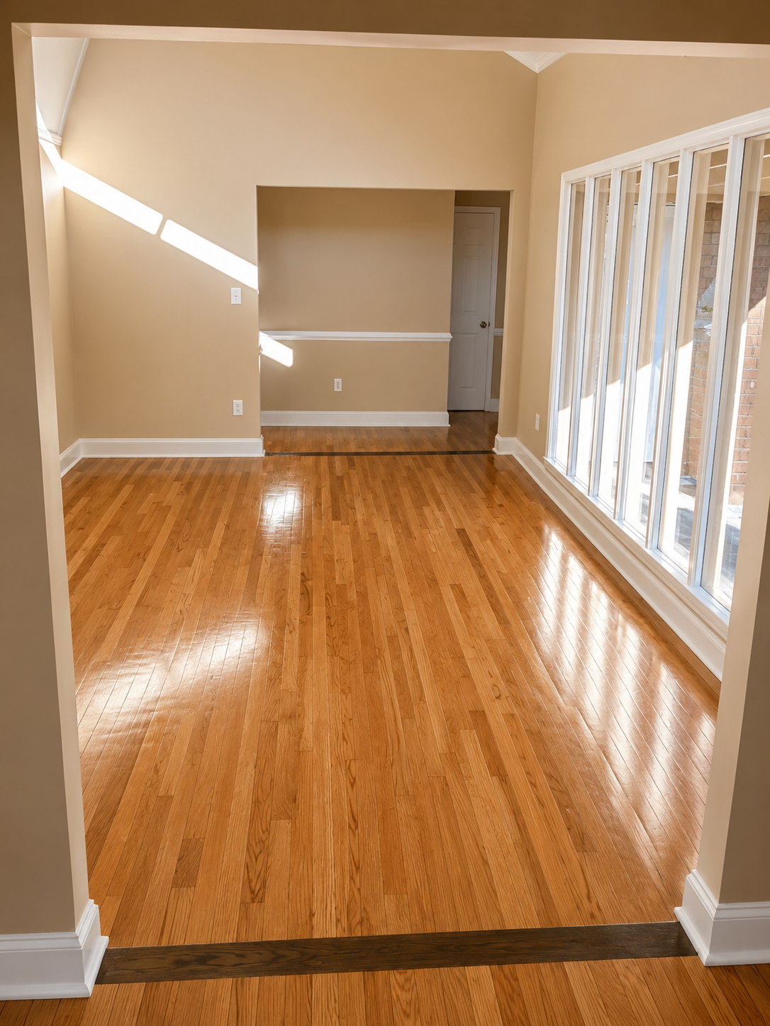 Sun-filled sitting room with refinished oak hardwood flooring and wall of windows